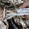 Décapsuleur d'un outil multifonction NexTool ouvrant une bouteille en verre en plein air