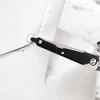 Tournevis d'un outil multifonction serrant une vis sur une surface blanche.