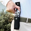 Homme retirant une clé à molette multifonction de son étui en nylon noir fixé à la ceinture.