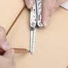 Mesure précise avec la règle graduée d'un couteau suisse multifonction NexTool sur un carnet en papier.