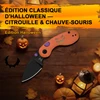 Couteau de poche pliant édition Halloween orange et noir avec motif citrouille sur une table en bois décorée