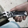 Main serrant une pince multifonction NexTool W40 avec clé à molette pour visser un écrou métallique.