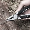 Pince multifonction NexTool W40 coupant un fil de fer sur une bûche de bois en extérieur.