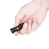Olight I1R 2 Pro mini torche noire tenue en main pour l'éclairage quotidien et extérieur.