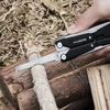 Scie de poche de la pince multifonction NexTool W40 coupant une branche en bois pour le camping