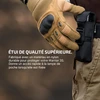 Main gantée prenant une lampe de poche Olight Warrior 3S dans son étui de ceinture tactique en nylon noir.