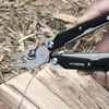Pince multifonction NexTool W40 coupant un fil métallique en extérieur.