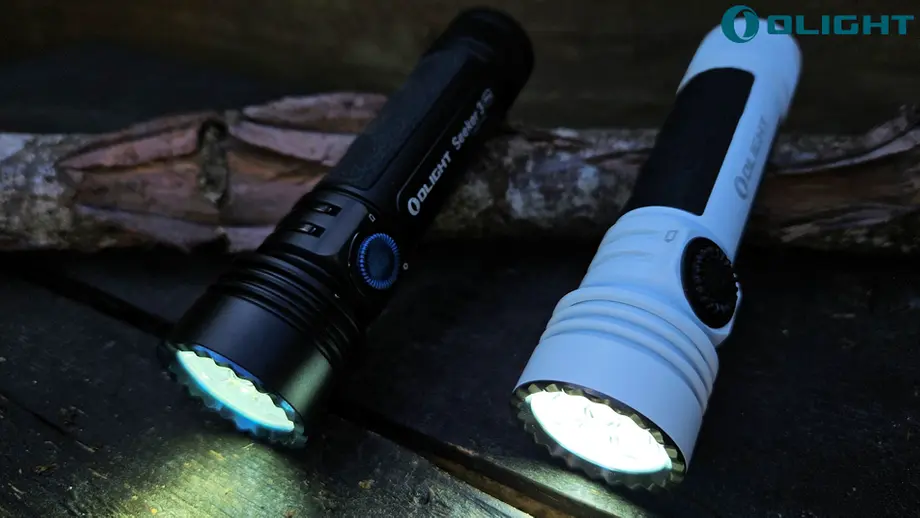 Olight Seeker 3 Pro noire et lampe blanche allumées sur du bois.