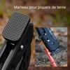 Marteau pour piquets de tente robuste enfonçant une sardine métallique rouge en camping sauvage.
