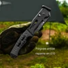 Couteau tactique noir avec poignée antidérapante en G10 tenu par une main gantée en extérieur