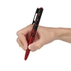 Stylo lampe Olight Open 3 rouge et noir tenu en main pour écriture et éclairage quotidien EDC