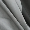 Gros plan sur le tissu gris texturé et plissé de la lampe de poche Olight Arkfeld Ultra pour un usage quotidien