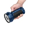 Main tenant la puissante lampe de poche Olight Marauder 3 bleue et noire, idéale pour le camping et la recherche.