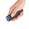 Main tenant la lampe torche Olight Arkflex, lumière de travail rechargeable, bouton de commutation bleu