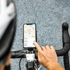 Cycliste utilisant un smartphone sur support de guidon pour la navigation et la recherche de restaurants.